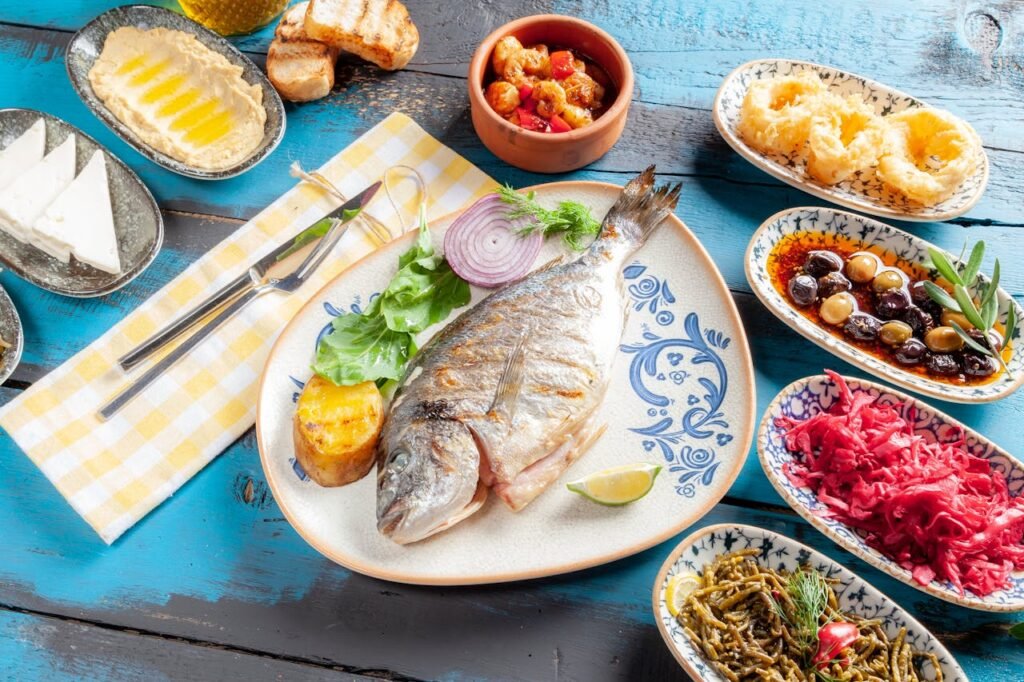 pexels photo 11714370 A vibrant Mediterranean meal featuring grilled fish and assorted appetizers on a rustic table.