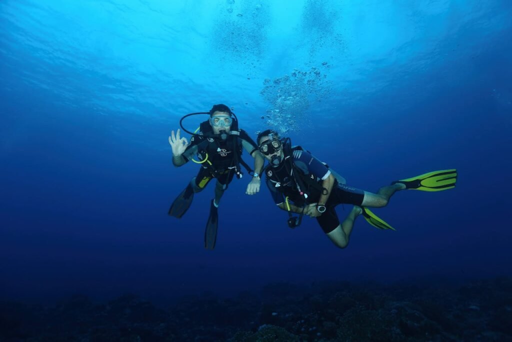 pexels photo 14565669 Two scuba divers with gear exploring the deep blue ocean, captured under natural light.